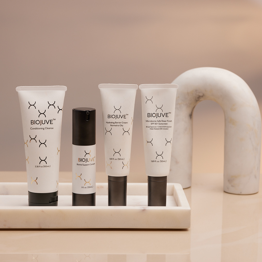 BIOJUVE skincare products on a marble surface with a neutral background