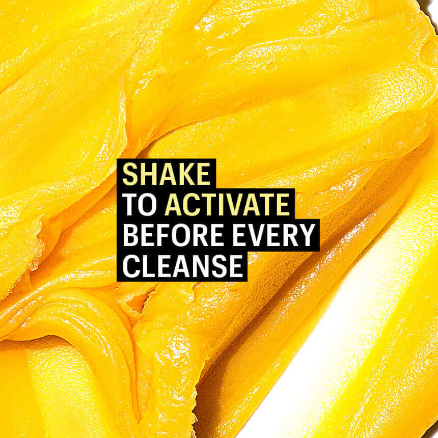 Close-up of yellow scrub with text 'Shake to activate before every cleanse' on a white background