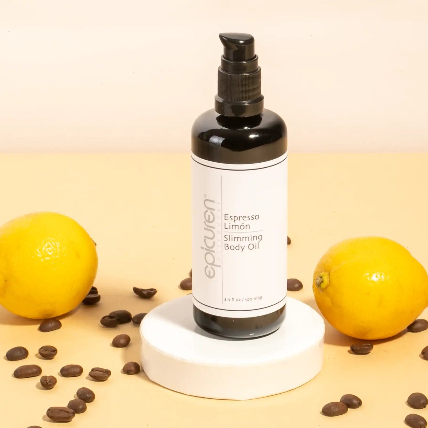 Body oil bottle with lemons and coffee beans on a beige background
