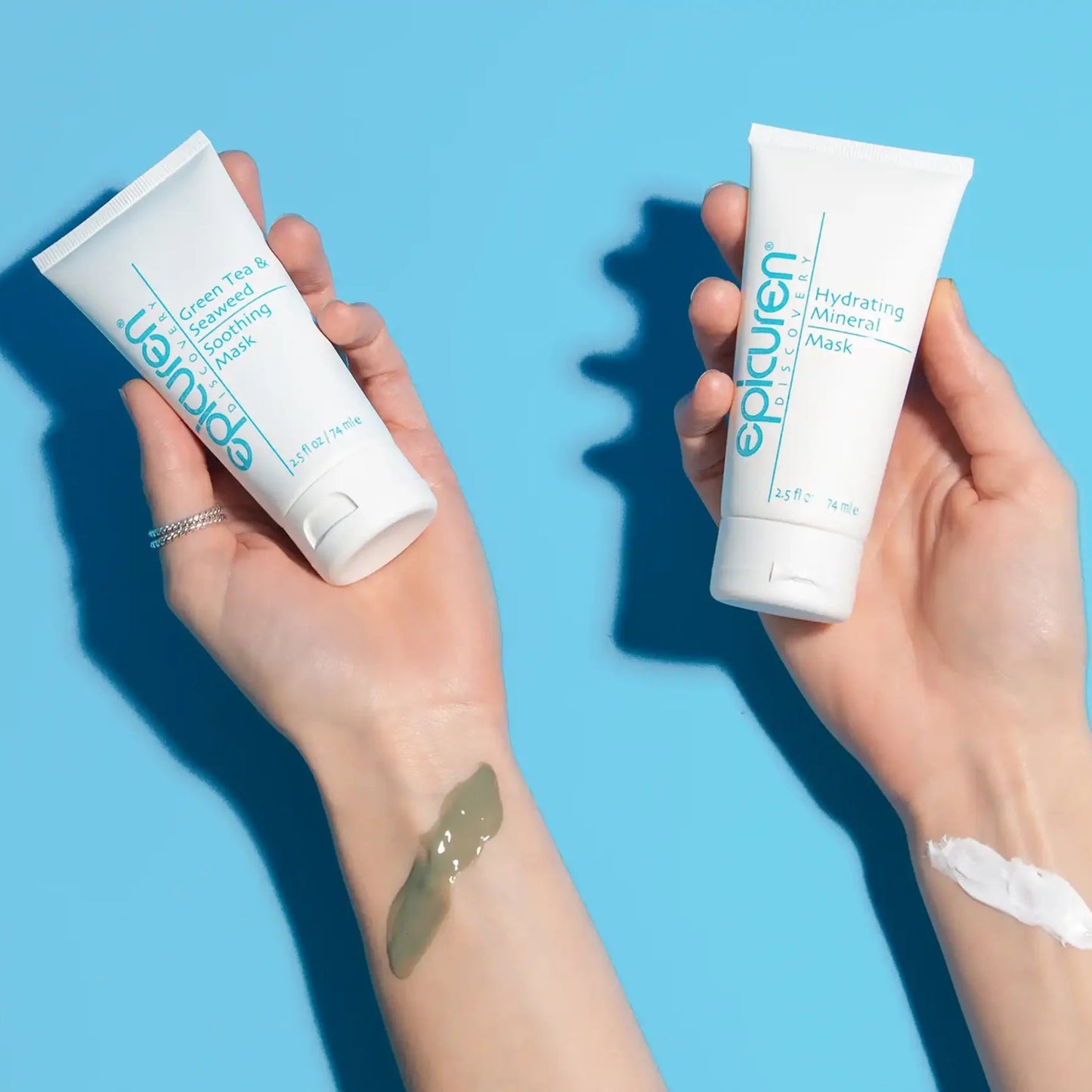 Two hands holding Epicuren skincare products against a blue background