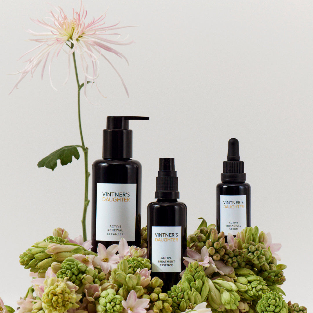 Vintner's Daughter skincare products with flowers on a light background