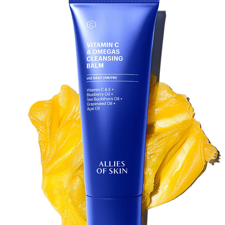 Blue cleansing balm tube with yellow leaves on a white background