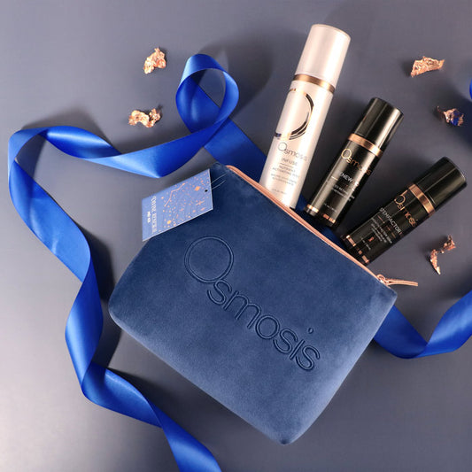 Osmosis skincare products with a blue pouch on a gray background