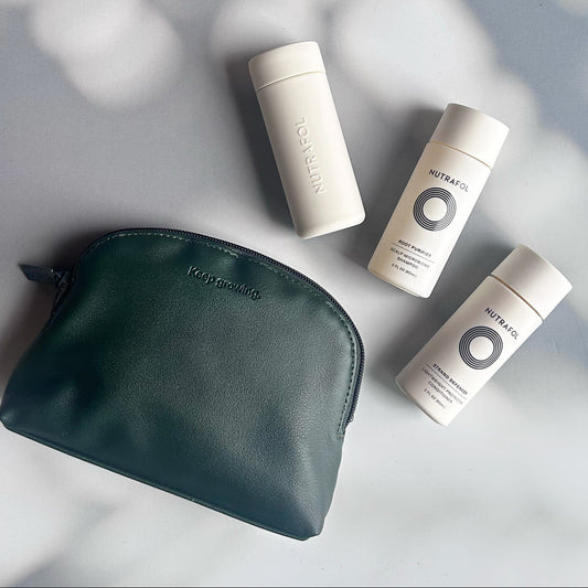 Nutrafol hair care products with a green pouch on a light gray background