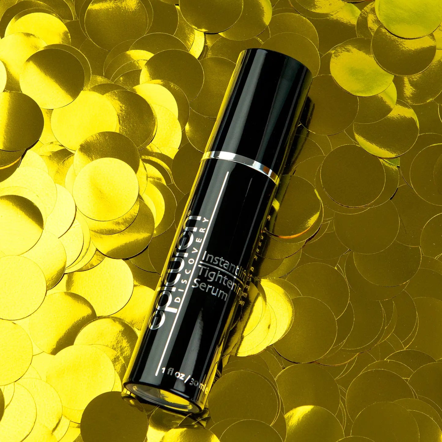 Black serum bottle on a yellow confetti background