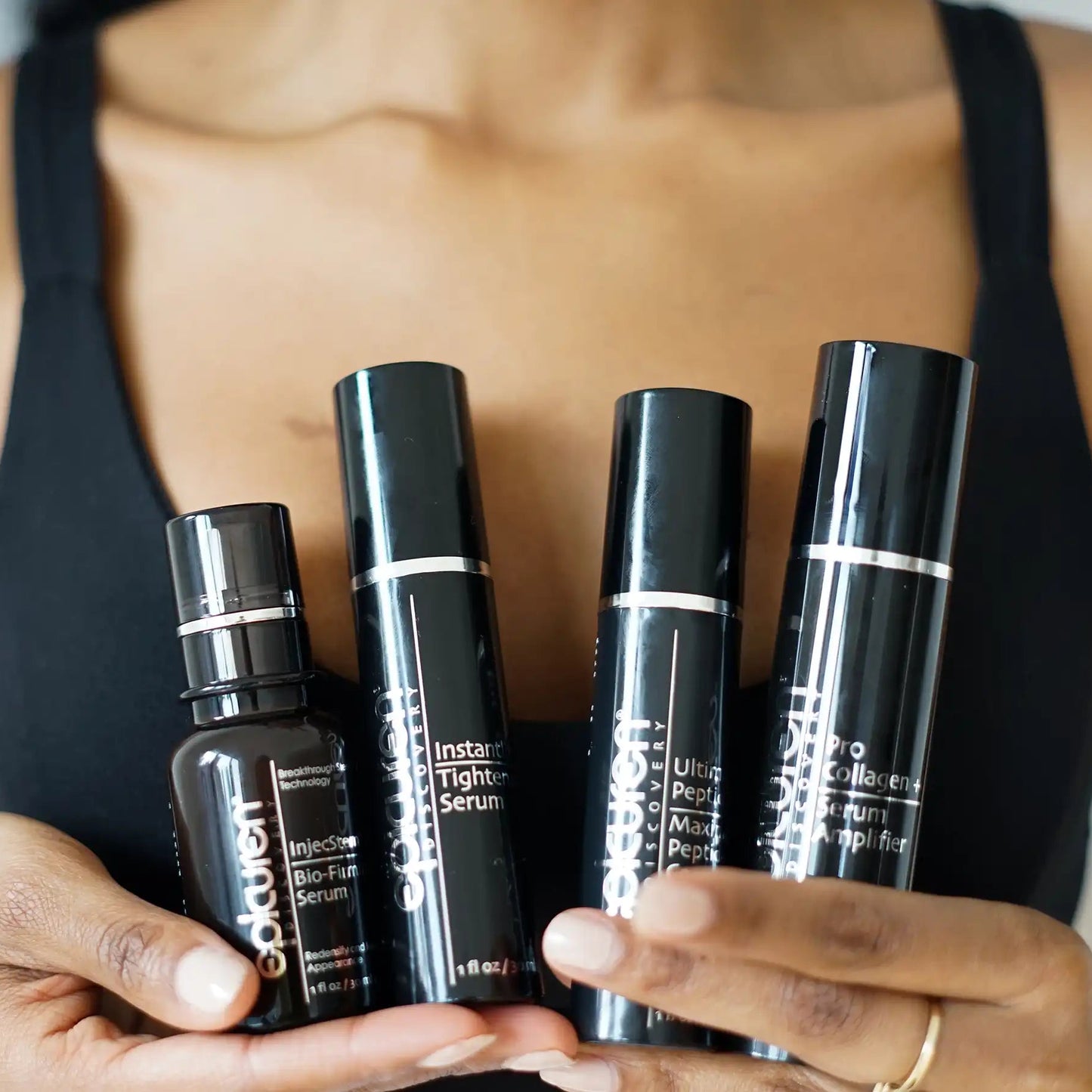 Person holding a set of skincare products with visible branding.