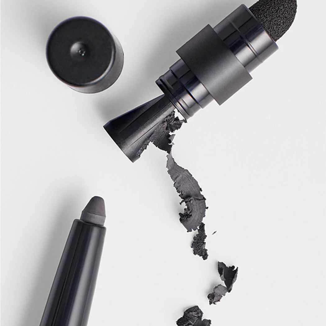 Black makeup pencil with shavings on a white background