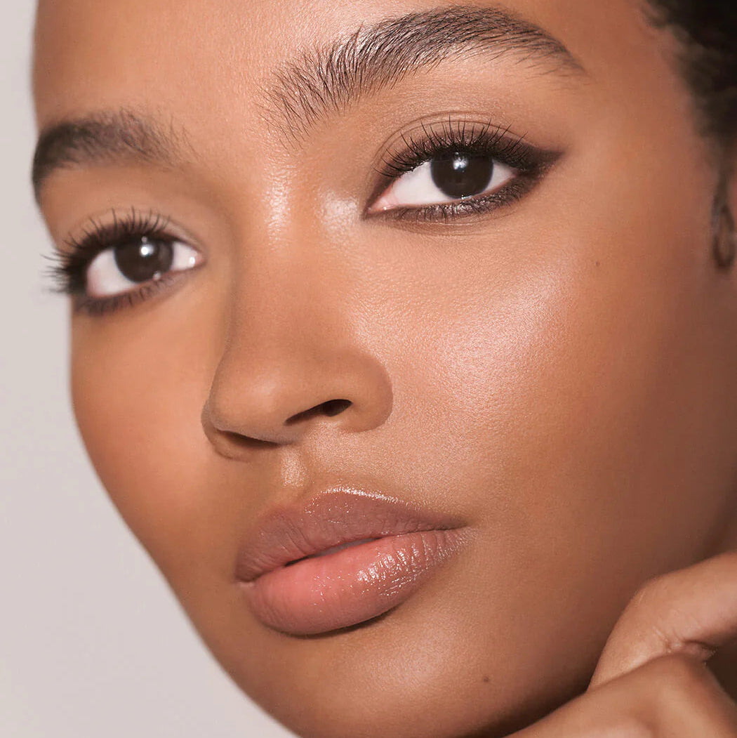 Close-up of a woman's face with makeup on a neutral background