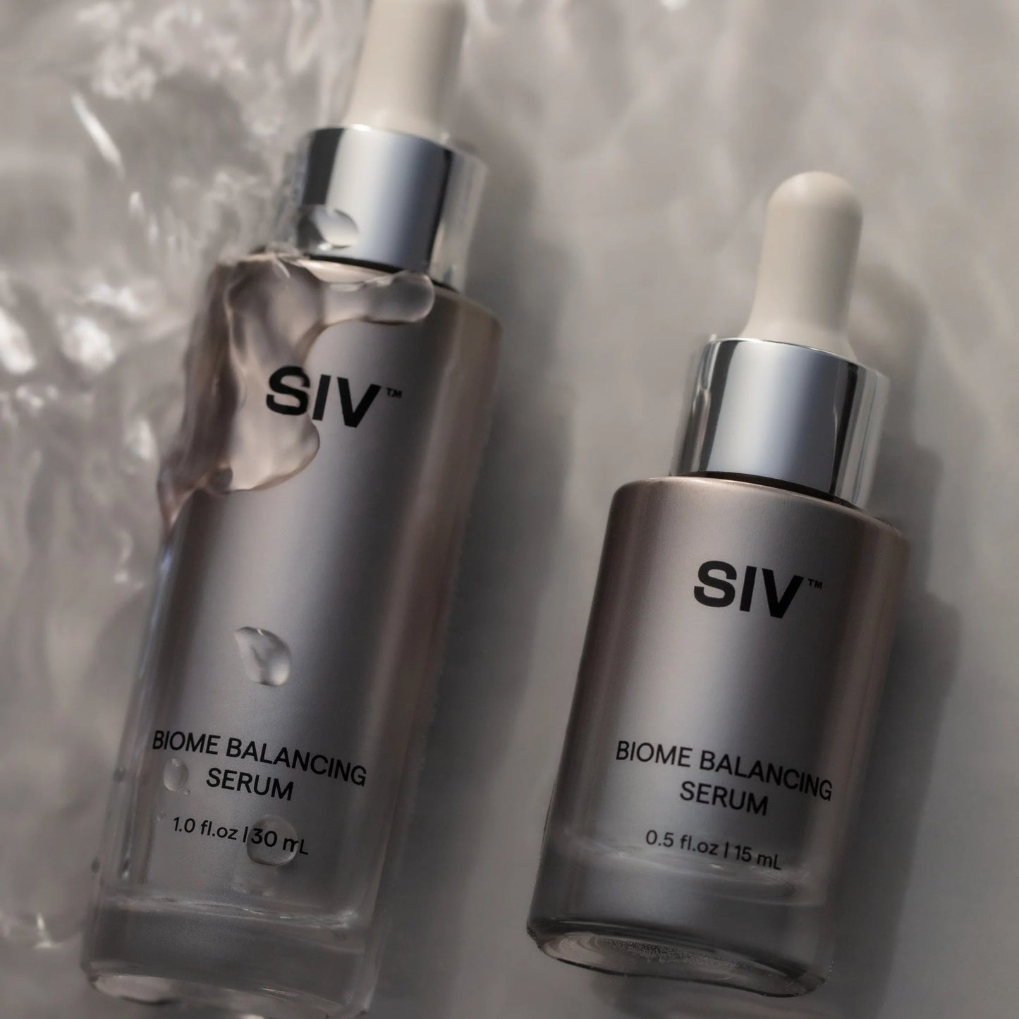 Two SIV Biome Balancing Serum bottles on a textured surface