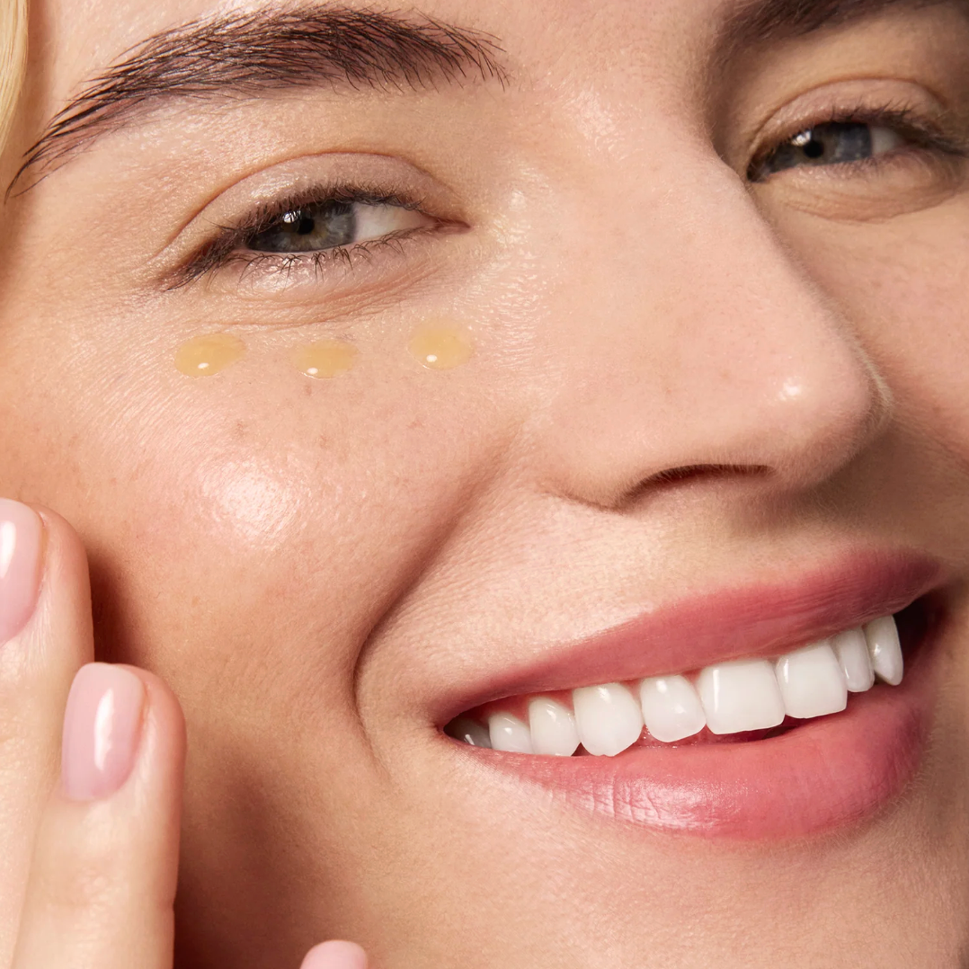 Close-up of a woman's face with cosmetic product application on cheek