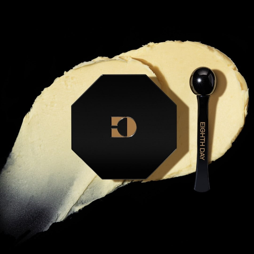 Eighth Day Overnight Eye Cream black container with cream colored product spread under the container. 