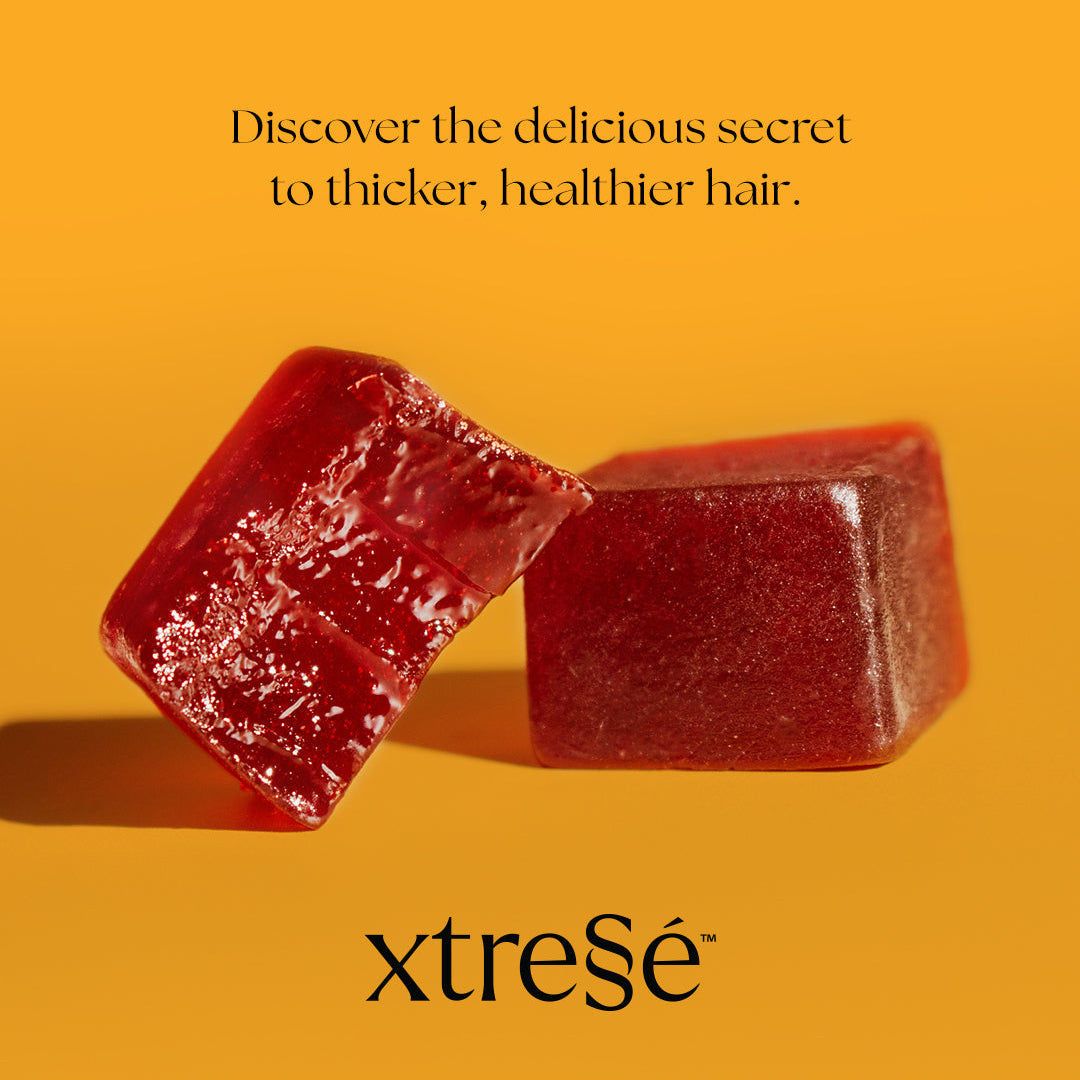 Two red translucent gummy candies on a bright yellow-orange background with the text 'Discover the delicious secret to thicker, healthier hair.' and the brand name 'xtressé' below.