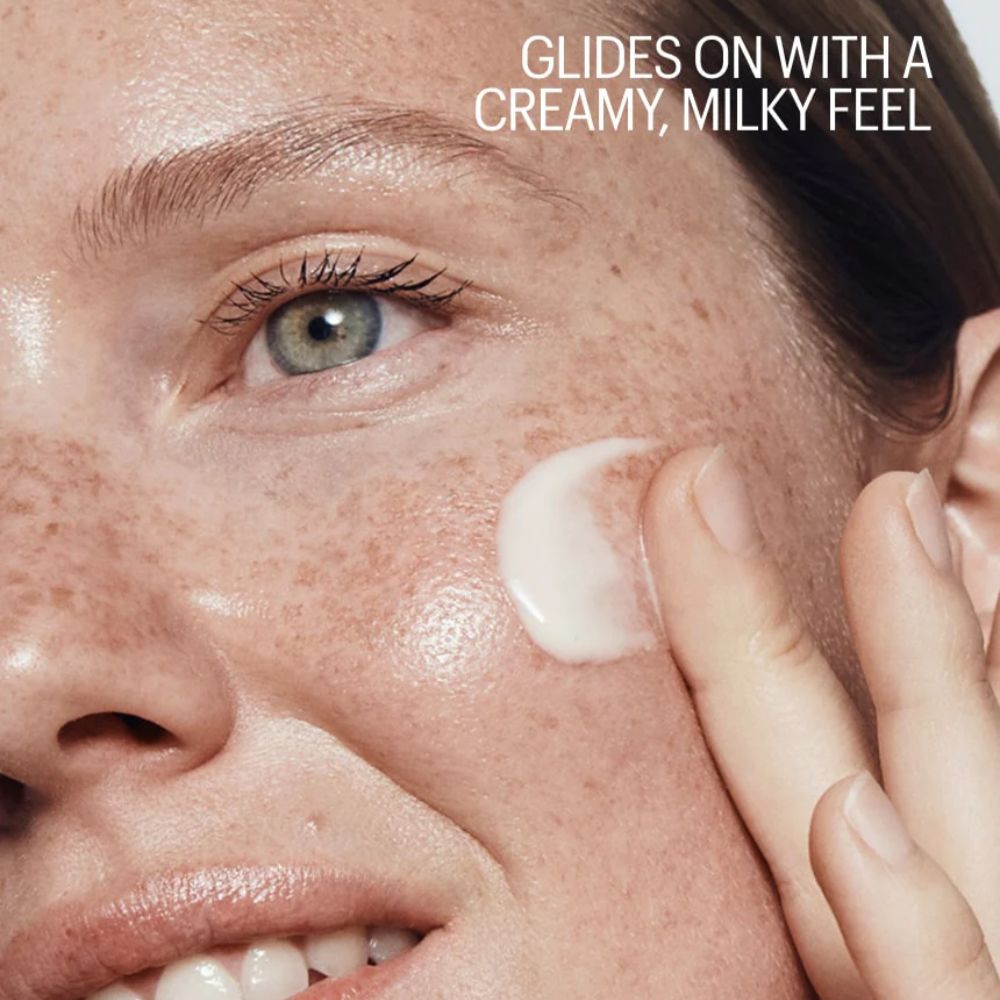Close-up of a person applying cream to their face with text describing the texture.