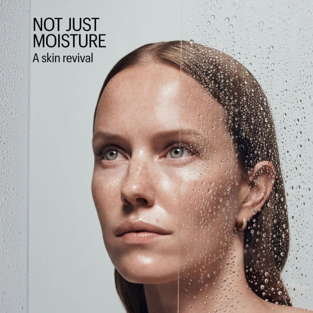 Woman with moisturized skin and text 'Not Just Moisture: A skin revival' on a gray background