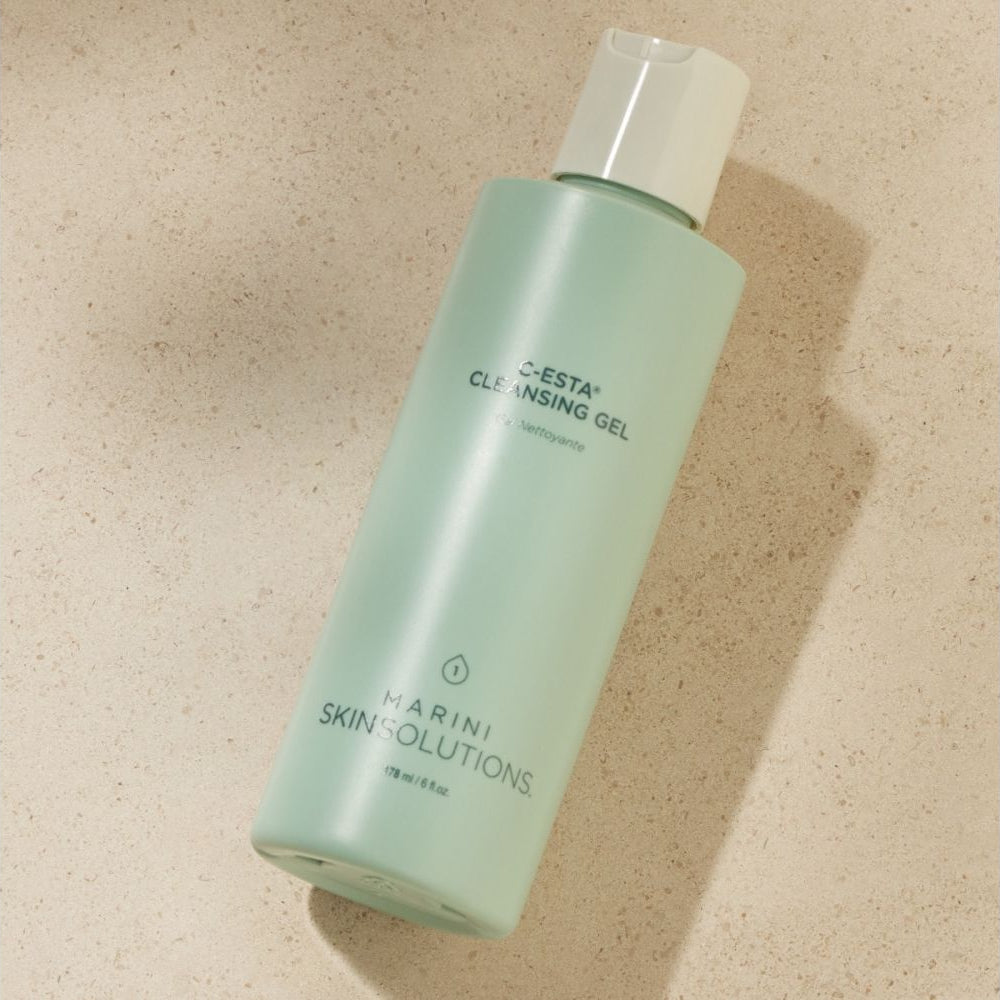 Green bottle of Harini Skin Solutions cleansing gel on a beige background